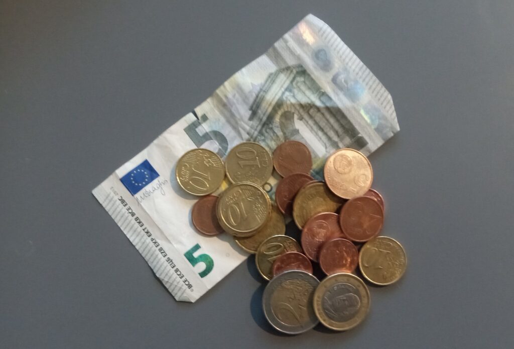 Five euro bill with euro coins