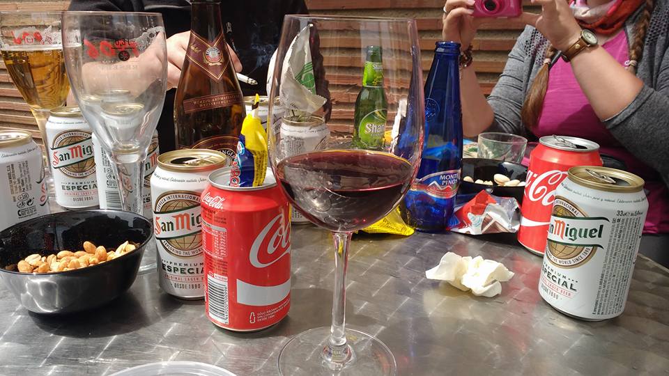 Beer cans and wine glasses on a table.