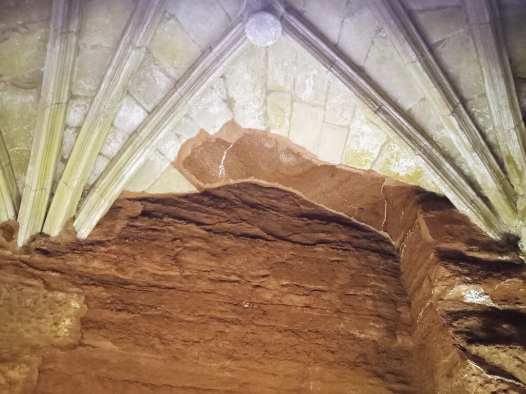 A stone church emerges from a terracotta mountain