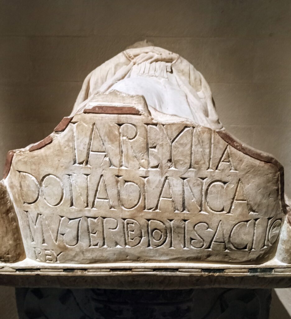 A carved tomb with sculpture of person lying down